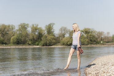 Carefree mature woman splashing in a river - UUF17590