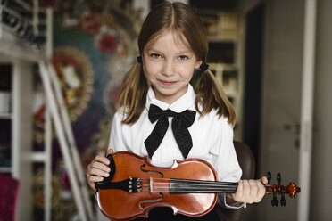 Porträt eines lächelnden Mädchens mit einer Geige zu Hause - EYAF00219