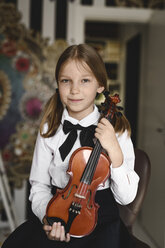 Porträt eines lächelnden Mädchens mit einer Geige zu Hause - EYAF00220