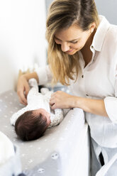 Mother with her newborn baby on changing table - ERRF01293