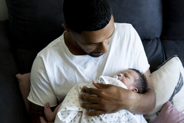 Liebevoller Vater hält sein neugeborenes Baby auf der Couch - ERRF01329