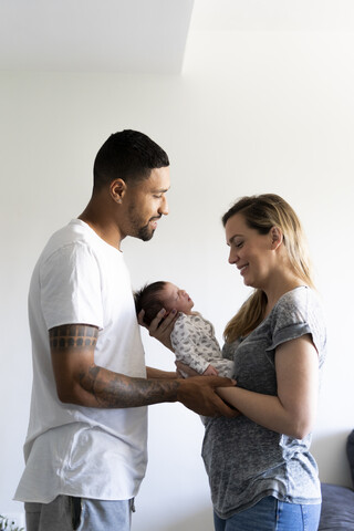 Happy parents holding newborn baby at home stock photo