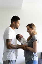 Glückliche Eltern halten ihr neugeborenes Baby zu Hause - ERRF01352