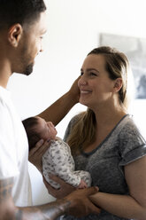 Happy parents holding newborn baby at home - ERRF01353