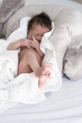 Neugeborenes Baby auf Decke im Bett liegend, lizenzfreies Stockfoto