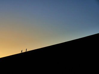 Silhouette of two people hiking on Big Daddy at sunrise, Namib desert, Namibia - VEGF00246