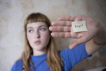 Schülerin hält sich die Hand vor die Augen, auf der Hand ein Zettel mit dem Wort Angst - FLLF00184