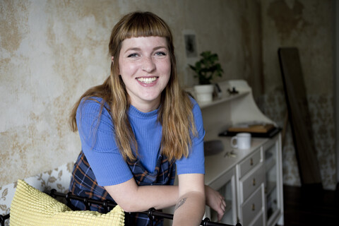 Studentin in ihrem Zimmer mit Blick in die Kamera, lizenzfreies Stockfoto