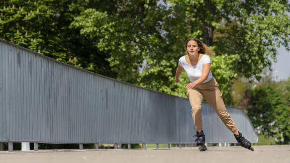 Junge Frau auf Inline-Skates in der Stadt, Waiblingen, Deutschland - STSF01984