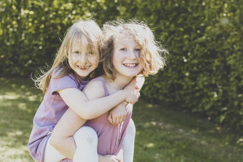 A big sister carrying her small sister, Girl power stock photo