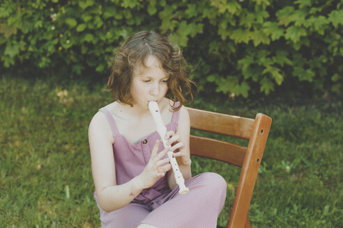 Ein Mädchen spielt Flöte im Garten - IHF00034