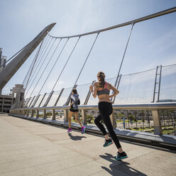 Kaukasische Frauen laufen auf Brücke - BLEF03677