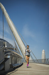 Kaukasische Frau läuft auf Brücke - BLEF03680