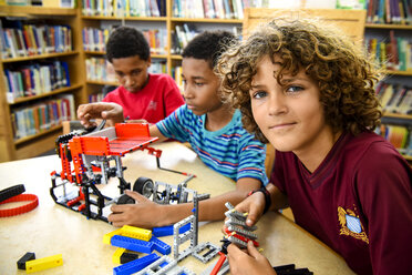 Boys assembling plastic blocks in library - BLEF03704