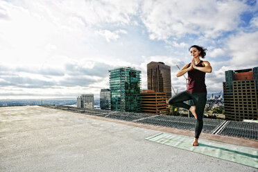 Caucasian woman doing yoga urban rooftop - BLEF03833
