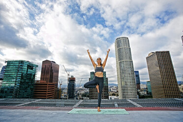 Caucasian woman doing yoga urban rooftop - BLEF03835