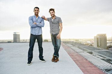 Stilvolle Männer posieren auf einem städtischen Hausdach - BLEF03844