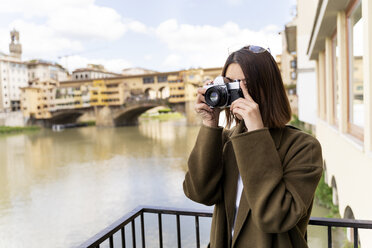 Italien, Florenz, junge Touristin beim Fotografieren am Ponte Vecchio - FMOF00630