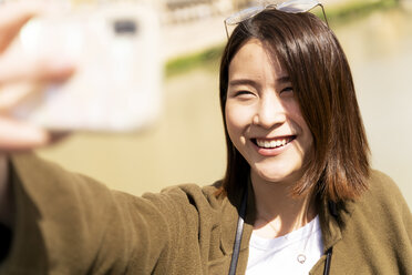 Happy young woman taking a selfie - FMOF00643