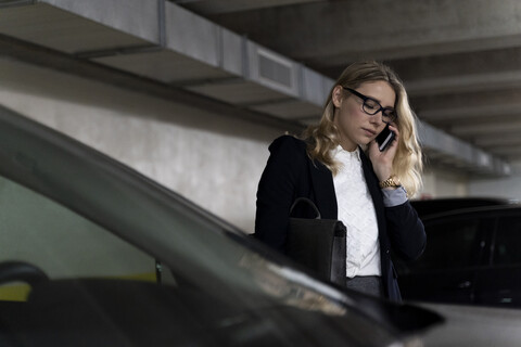 Businesswoman on the phone in car park stock photo