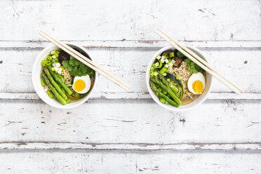 Two bowls of Ramen soup with egg, green asparagus, noodles, shitake mushroom and spring onions - LVF08048