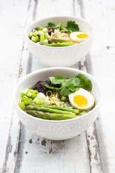 Two bowls of Ramen soup with egg, green asparagus, noodles, shitake mushroom and spring onions - LVF08049