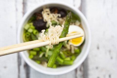 Schüssel Ramen-Suppe mit Ei, grünem Spargel, Nudeln, Shitake-Pilzen und Frühlingszwiebeln, lizenzfreies Stockfoto
