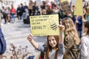 Mädchen hält ein Plakat auf einer Demonstration für den Umweltschutz - STBF00354
