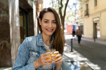 Young woman holding glass with fresh juice - AFVF02960