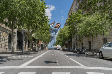 Young woman jumping on road in Barcelona - AFVF02963