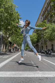 Junge Frau springt auf die Straße in Barcelona - AFVF02964