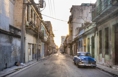 Geparkter blauer Oldtimer auf leerer Straße in der Abenddämmerung, Havanna, Kuba - HSIF00599