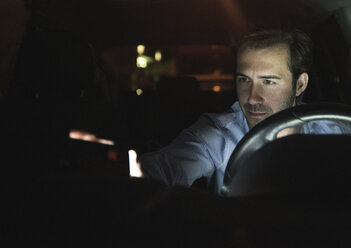 Young man in car at night - UUF17602