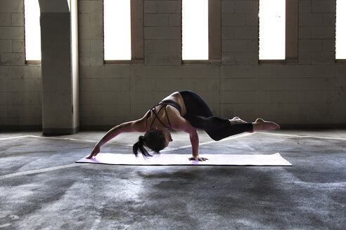 Caucasian woman practicing yoga in parking lot - BLEF03877