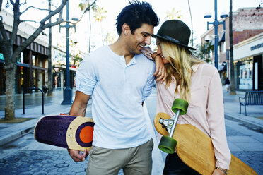 Caucasian couple carrying skateboards - BLEF03910