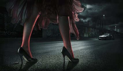 Woman wearing high heels on street at night - BLEF03943