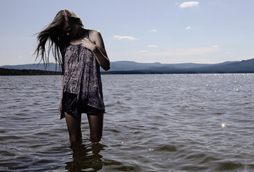 Woman wading in remote lake - BLEF04115