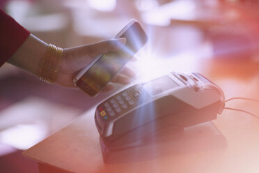 Indian woman paying with cell phone NFC technology - BLEF04135