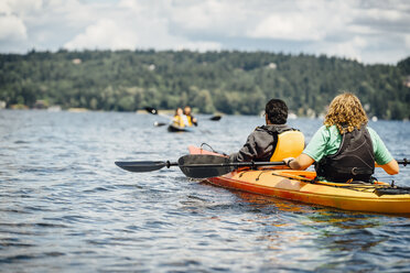 Man and woman holding paddles in kayak - BLEF04147