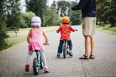 Vater beobachtet Tochter und Sohn beim Fahrradfahren - BLEF04149