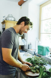 Caucasian man chopping vegetables in kitchen - BLEF04150