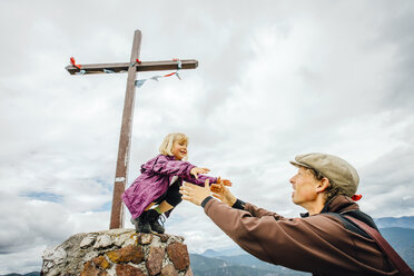 Kaukasischer Vater hilft seiner Tochter auf einem Felsen am Kruzifix - BLEF04173