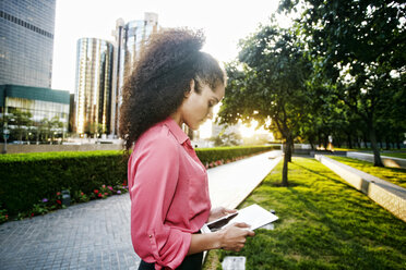 Hispanic businesswoman using digital tablet outdoors - BLEF04236