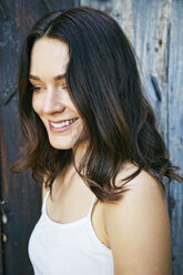 Smiling Caucasian woman near wooden fence - BLEF04298