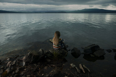 Kaukasisches Mädchen sitzt auf Felsen am See - BLEF04305