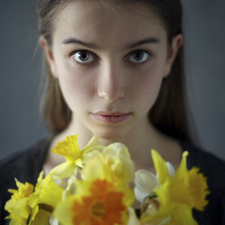 Kaukasisches Mädchen hält gelbe Blumen - BLEF04315