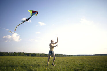 Caucasian girl running in field flying kite - BLEF04325