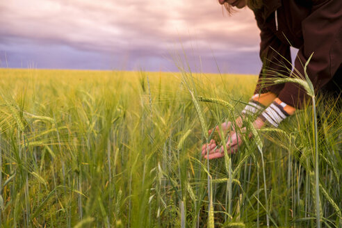 Kaukasische Frau hält Gras auf einem Feld - BLEF04359