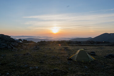 Campingzelt in einem kargen Feld bei Sonnenuntergang - BLEF04422