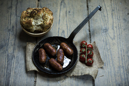 Gebratene Salsiccia in der Pfanne mit eingelegtem Brot und Mischbutter - MAEF12874